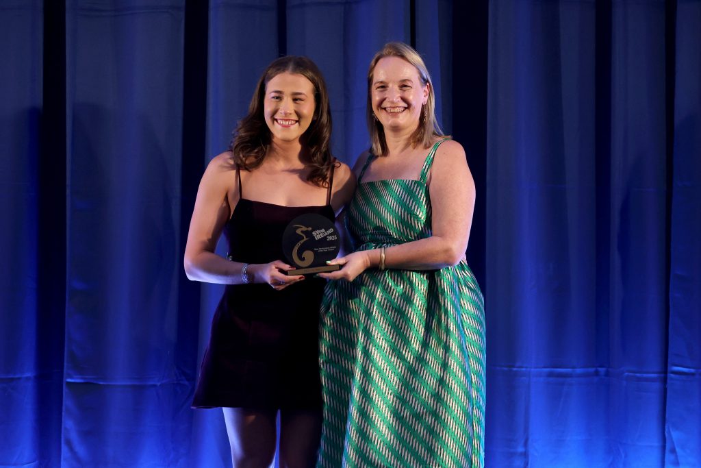 Paralympics Ireland president Lisa Clancy in a green dress presenting a trophy to Róisín Ní Riain in a black dress