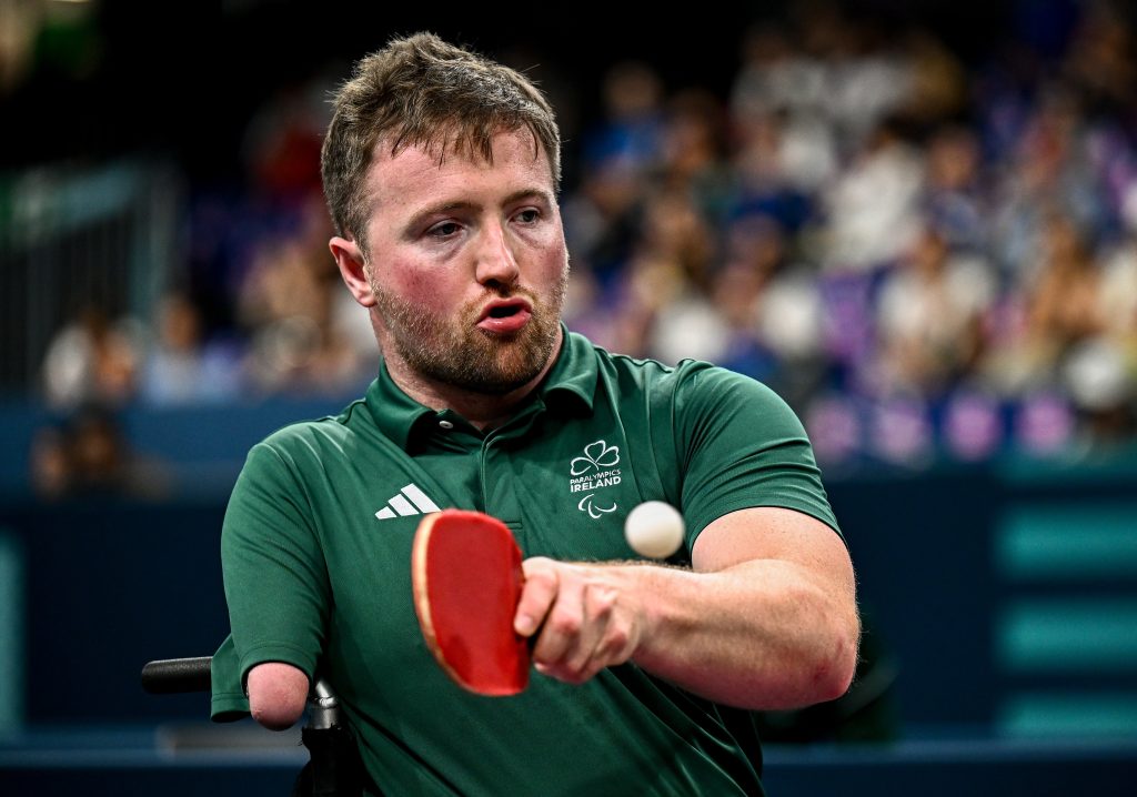Colin Judge playing Table Tennis in green Team Ireland t shiirt