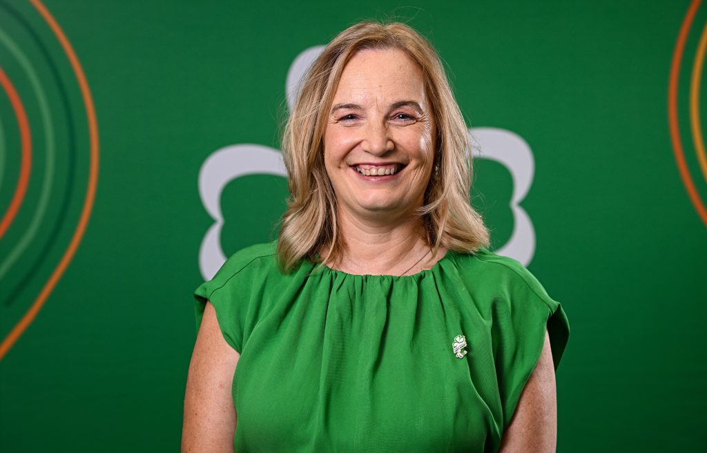 Lisa Clancy smiling in green dress with green background