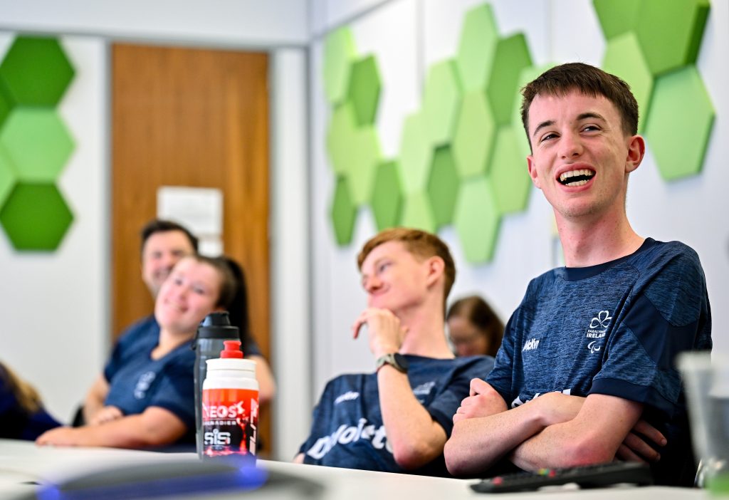 4 Athletes seated at a table laughing
