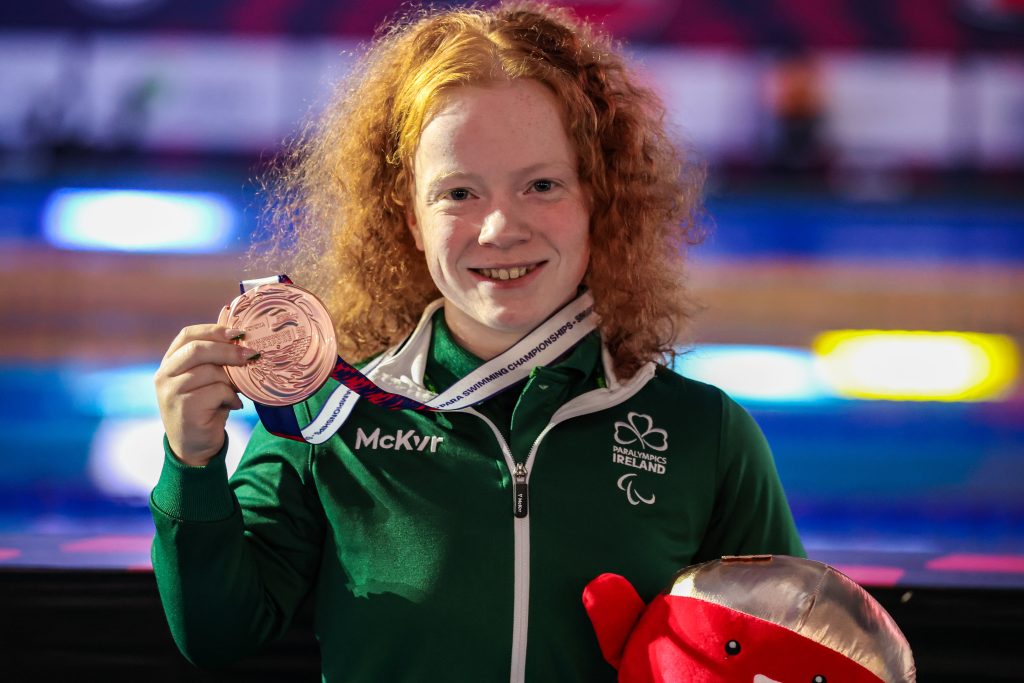 Dearbhaile Brady smiling and holding up her bronze medal at world championships 2025