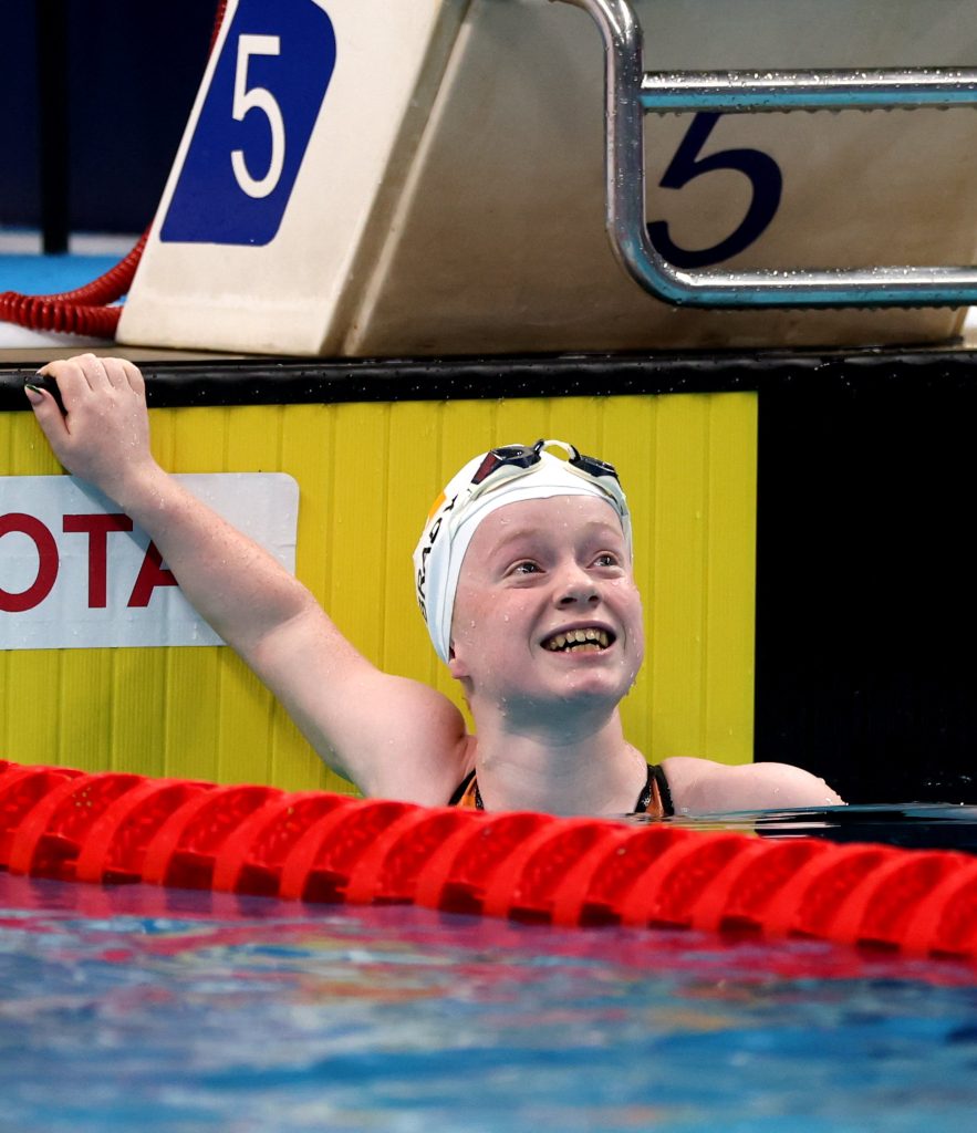 Dearbhaile Brady in the pool smiling looking up at results at Singapiore World Championships