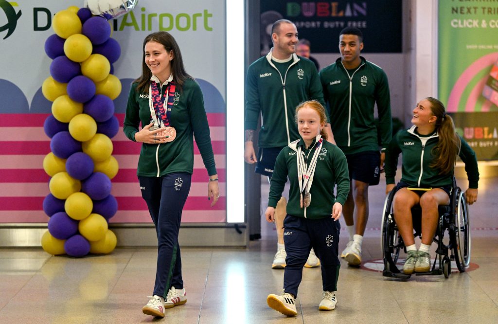 Para swimming squad returning to arrivals in Dublin airport. Smiling and happy. Five athletes