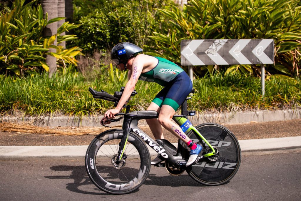 Picture of a triathlete in a green singlet cycling