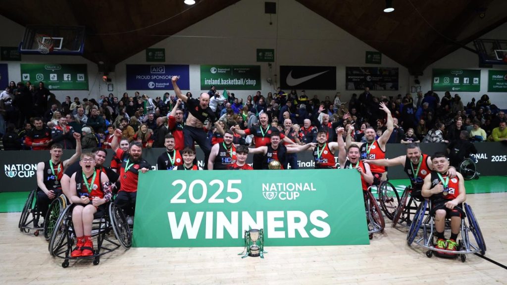 A picture of the winning Rebel Wheelers team celebrating behind a green sign that says 2025 National Cup Winners