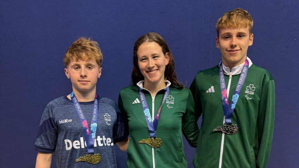 Luke O’Donoghue (left), Róisín Ní Ríain (centre) and Luke Brennan (right) stand wearing their medals after competing at the International German Championships in Berlin.