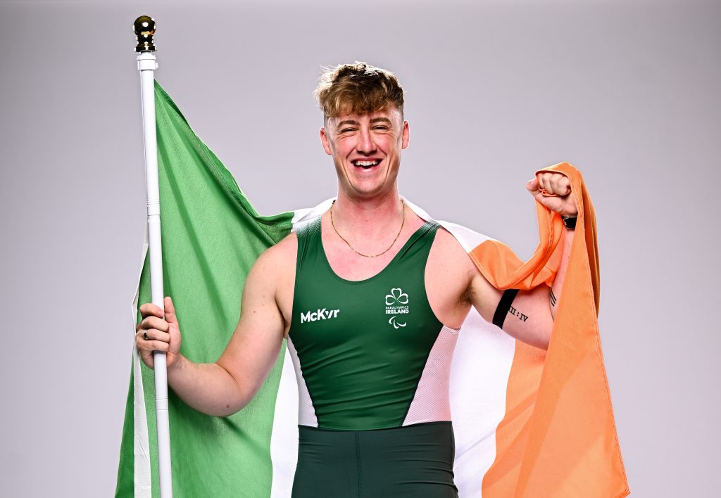Para rower Tiarnán O’Donnell of Ireland smiles while pictured during the Team Ireland announcement for the Paris 2024 Paralympic Games, holding the Irish flag.